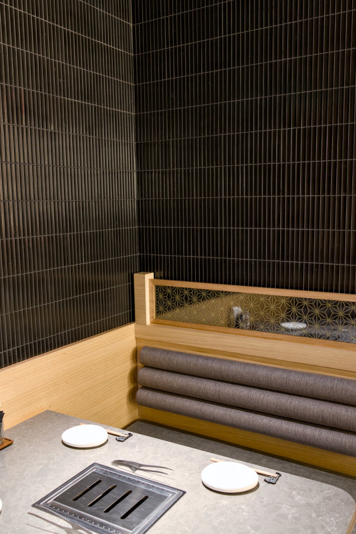 Corner dining booth with Yuki Border Speckled Black tiles at Gyu-Kaku Dubai