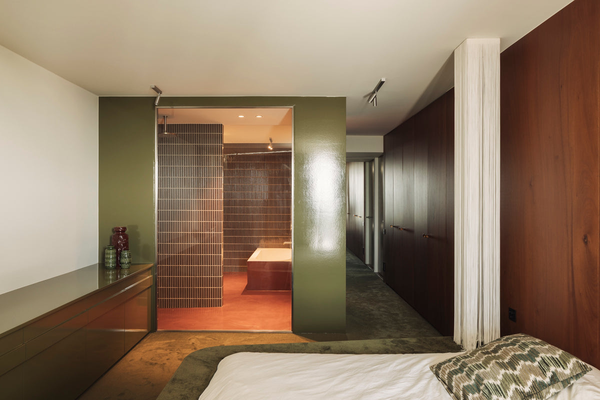 Private penthouse bedroom leading to a bathroom tiled in Kaji Border Burnt Russet
