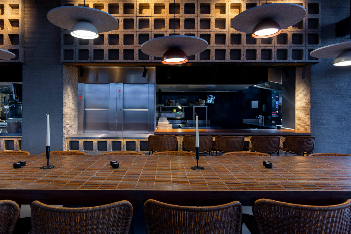 Front view of the tiled communal table facing the open kitchen at NEXT Amsterdam.