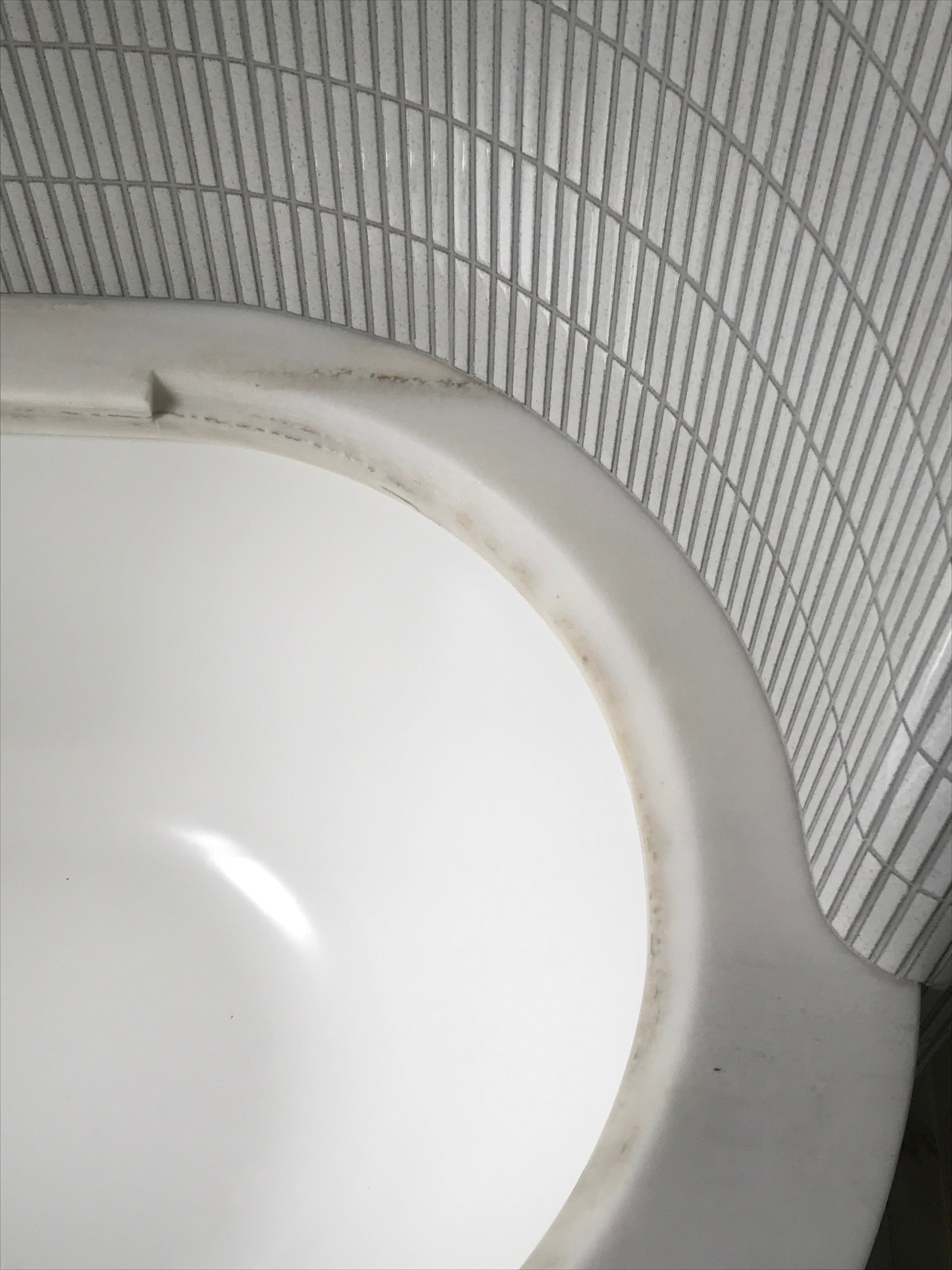 Detail of the curved bath geometry and vertically aligned tile courses.