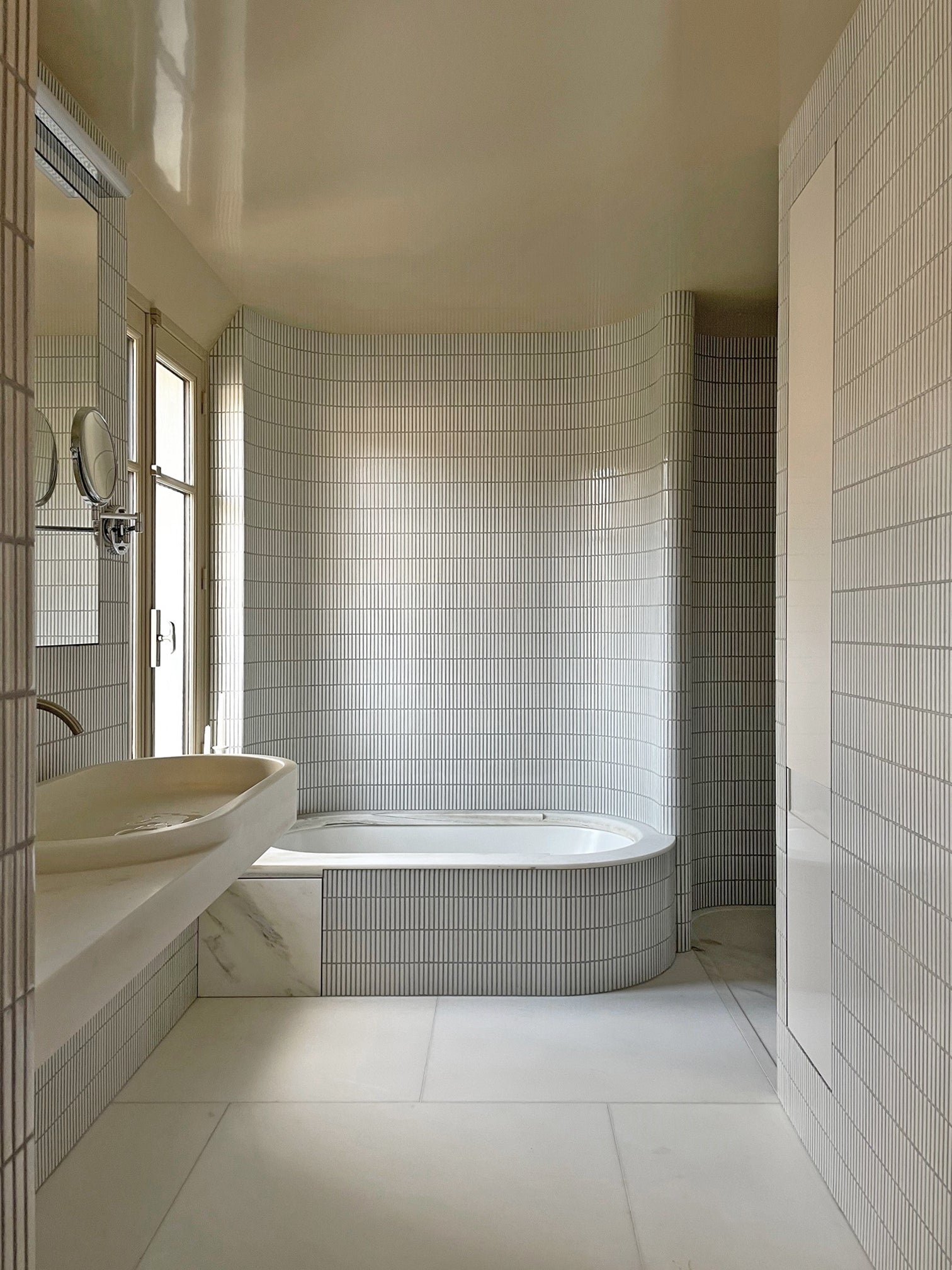 Paris bathroom by Federico Masotto Architecte with Yohen Speckled White tiled walls and bath.