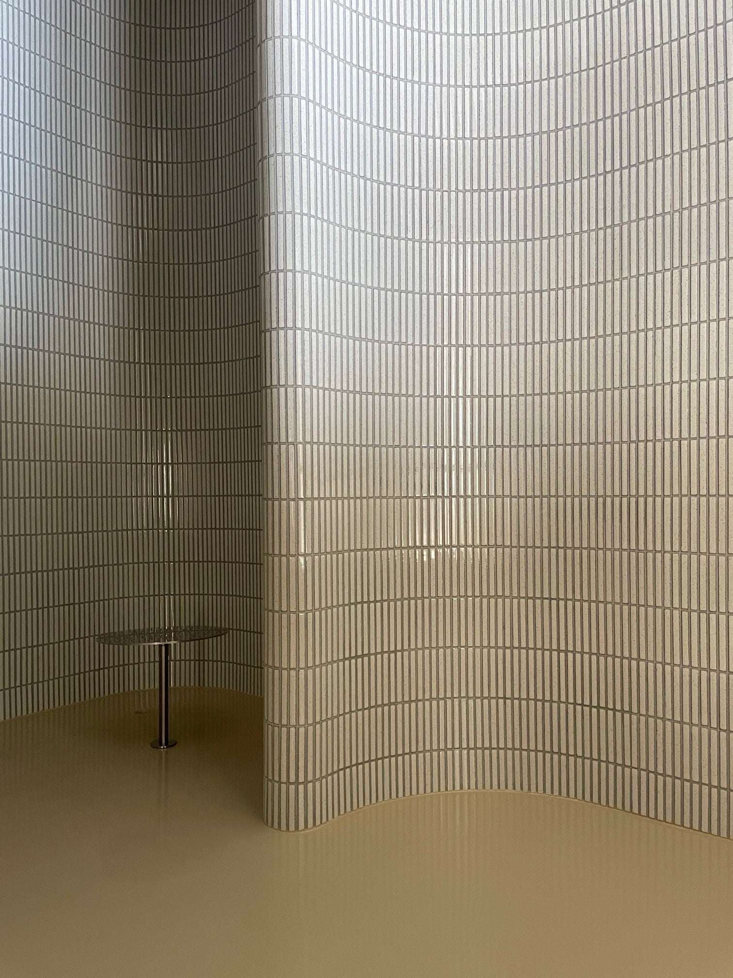 Shower partition clad in Yohen Speckled White tiles in a Paris residence.