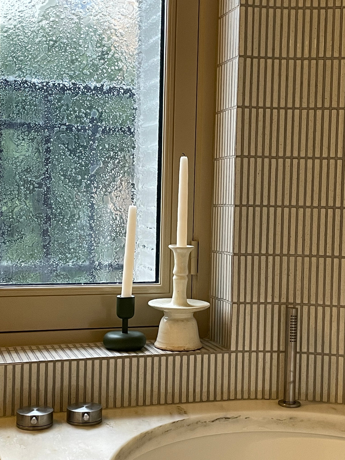 Window and bath in the Paris bathroom with Yohen Speckled White tiled surfaces.