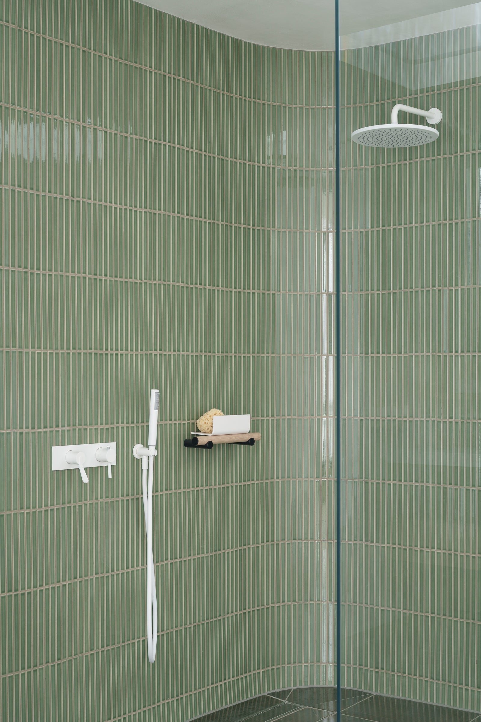 Curved shower lined with Arcaico Green tiles at Hanover Penthouse in Dublin.