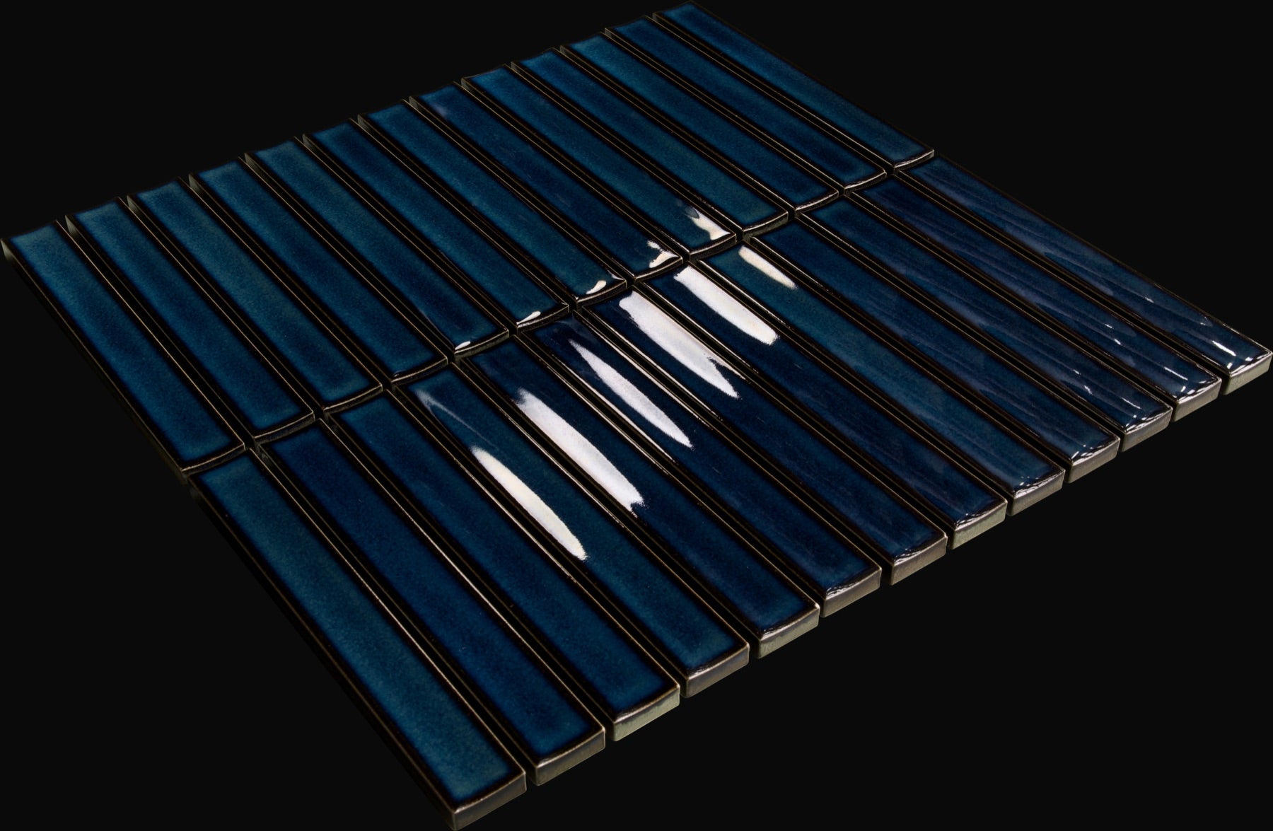 New angled studio photograph of a real Yuki Border Blue tile on a black background