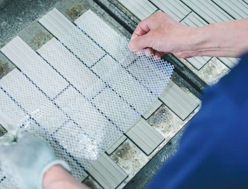 Small-format tile samples compared by hand