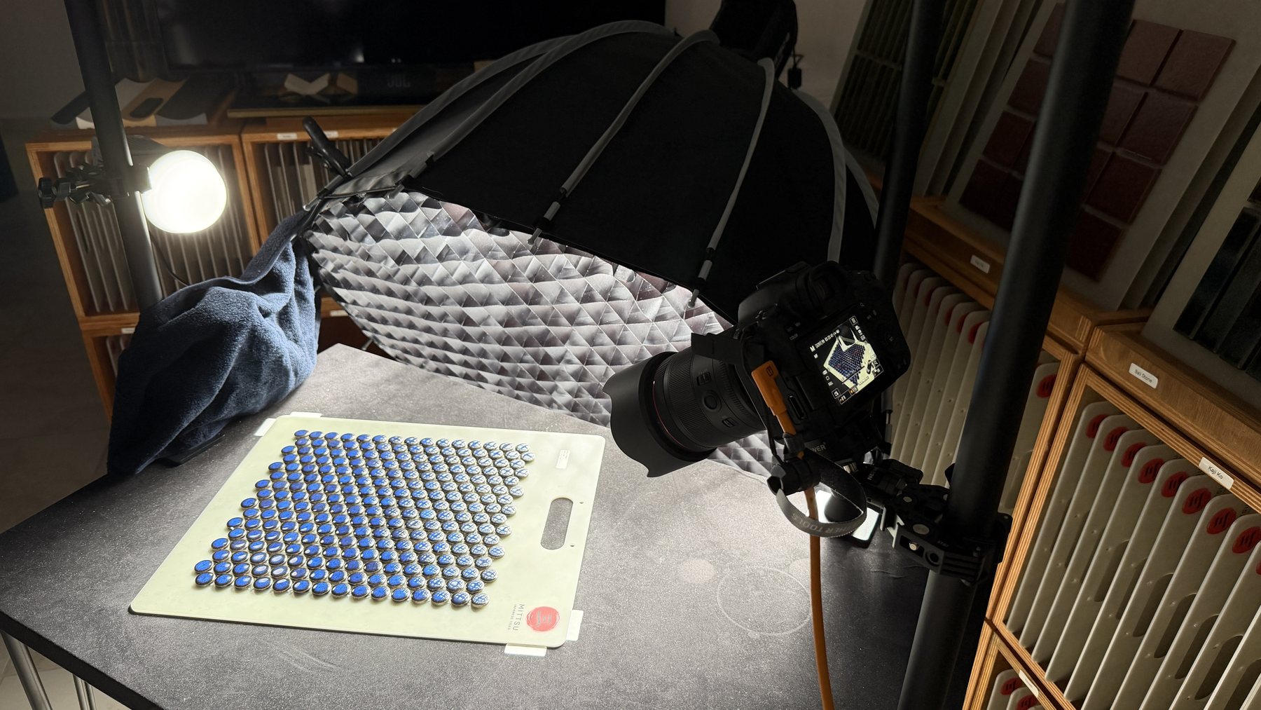 Closer view of the Mittsu photography rig showing the camera, softbox, small reflection light and tile positioning board